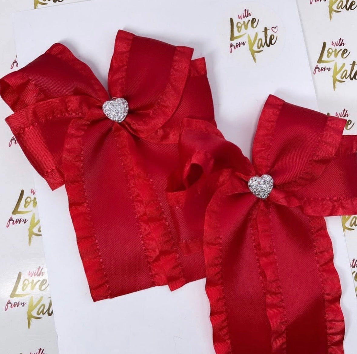 Red ruffle ribbon longtail bow with heart centres