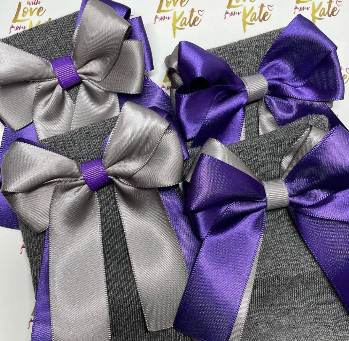 2 pairs of grey socks with grey & purple long tail bows