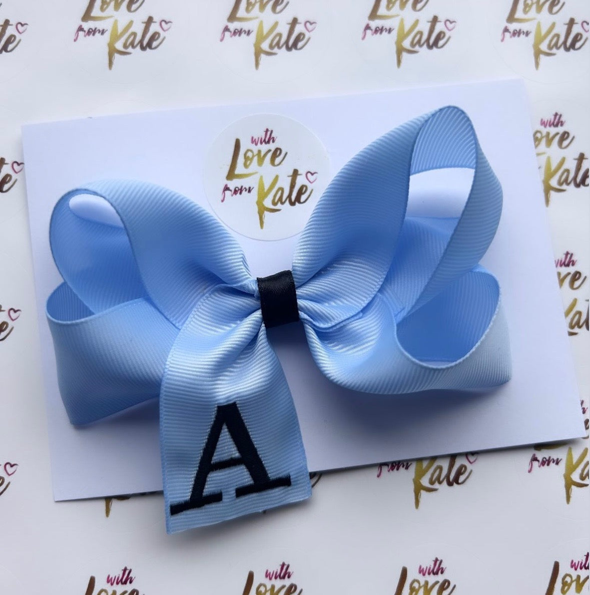 A light blue boutique bow with black embroidery
