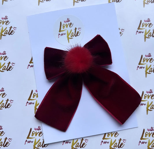 A maroon velvet long-tail bow with Pom