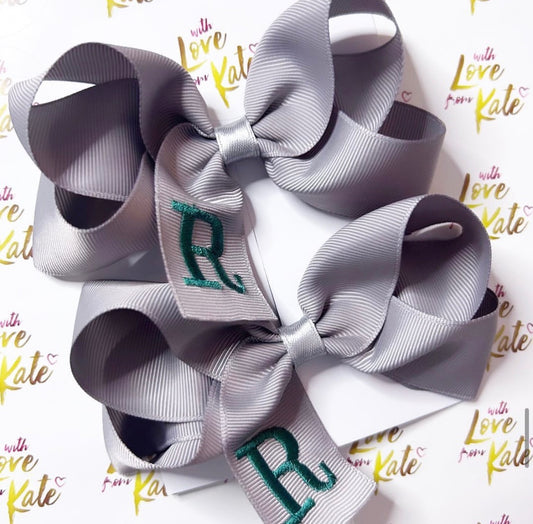 A grey boutique bow with dark green embroidery