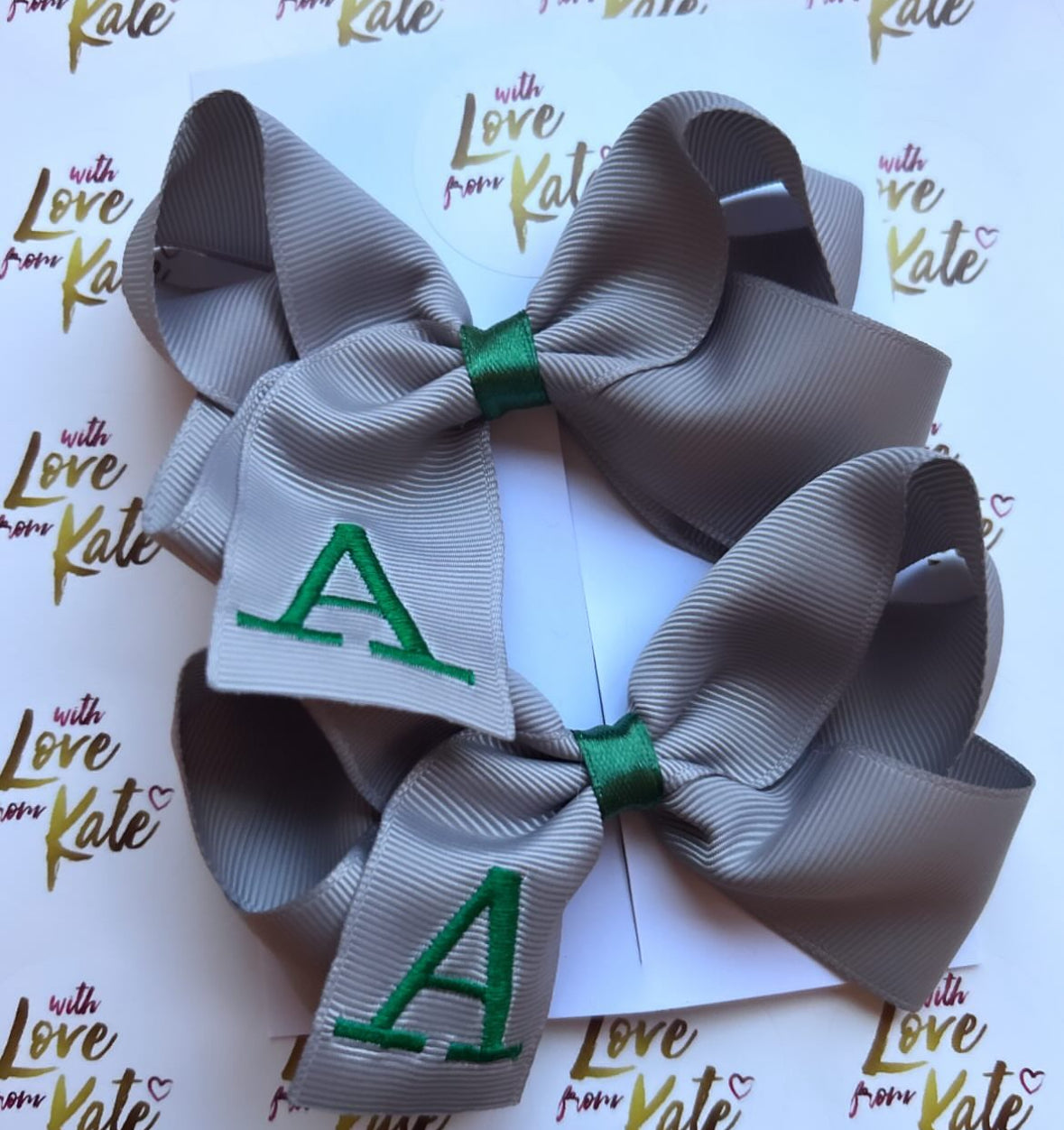 A grey boutique bow with dark green embroidery